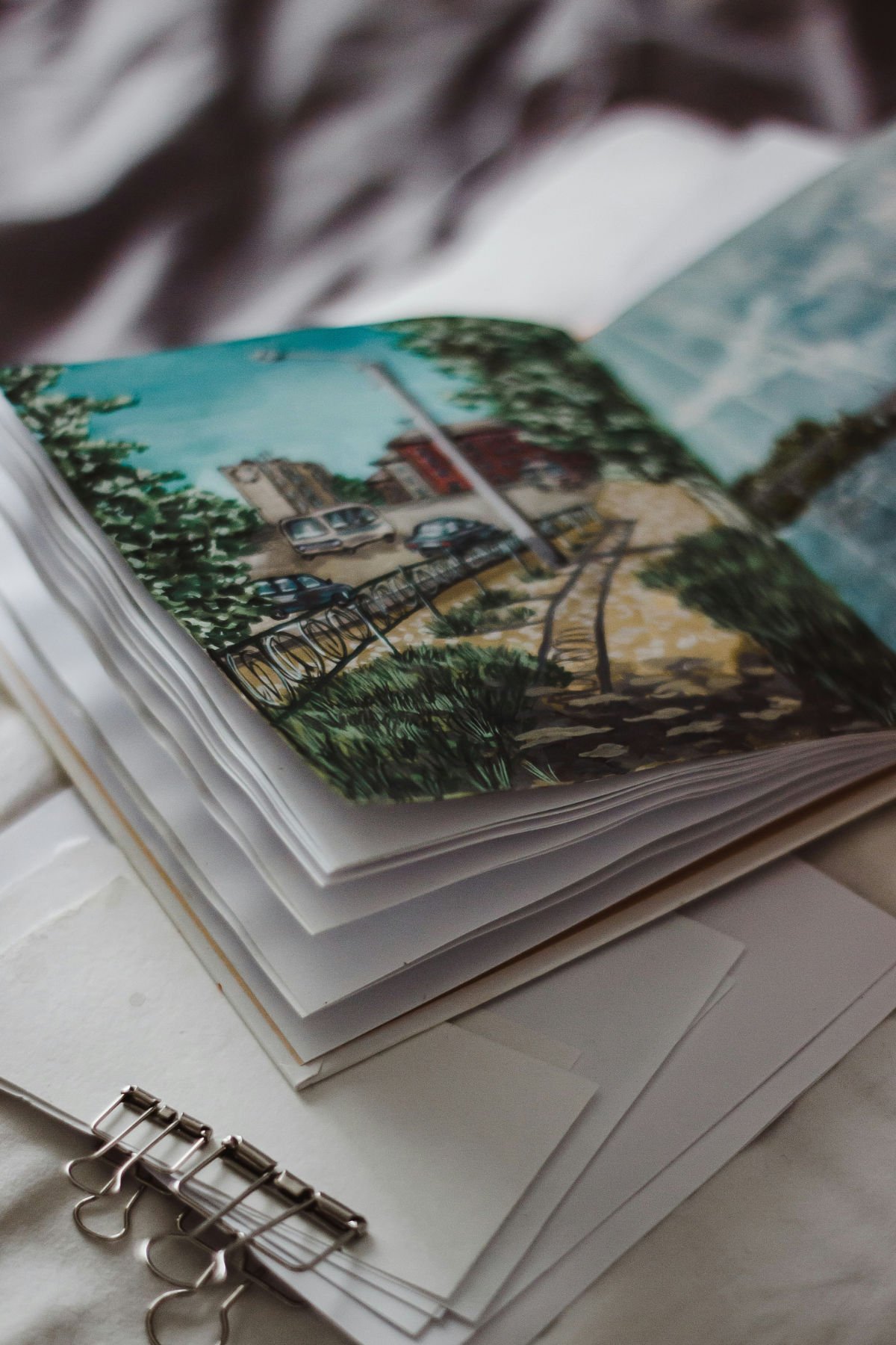 art portfolio with sketchbooks and work spread across a desk