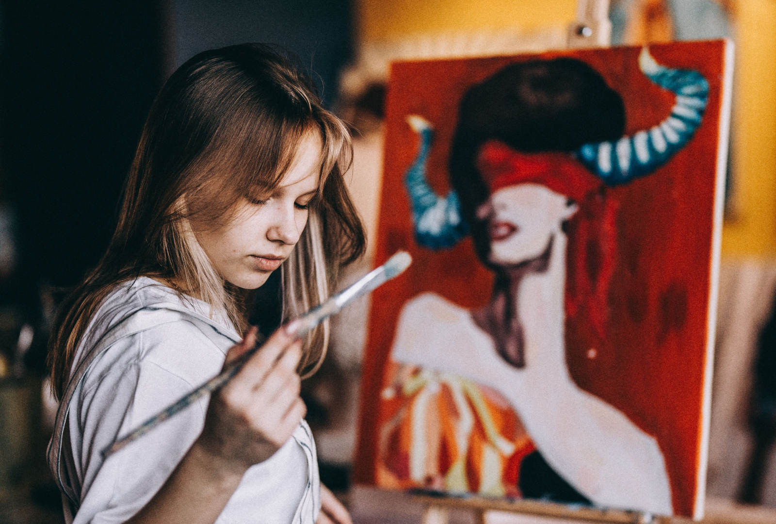 Student painting in an art studio, developing independent studio practice for a Fine Art portfolio application.