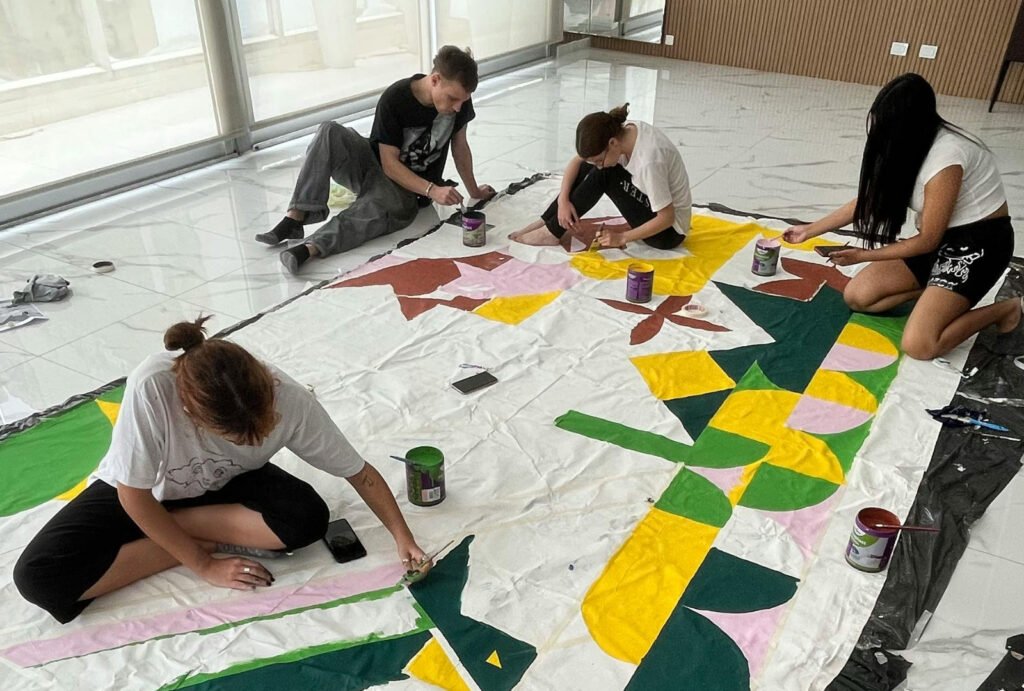 Students working on a large-scale painting project, reflecting the experimental studio practice expected in an SAIC Painting and Drawing portfolio.