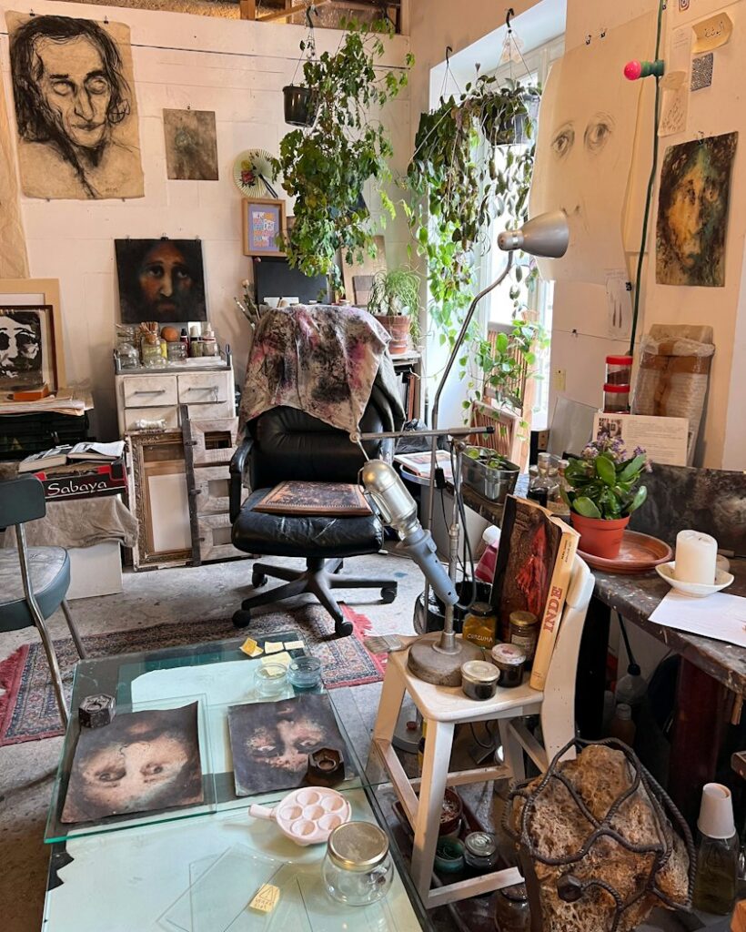 Crowded studio with portraits and paintings on every wall, for applicants meeting the Oxford Ruskin MFA portfolio requirements